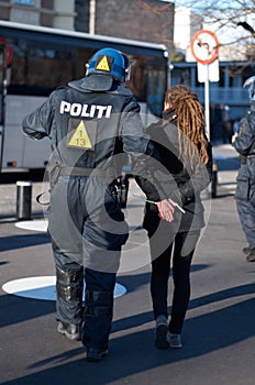 Police man arrest woman at protest in city, crime and law enforcement, security at demonstration in the street. Public