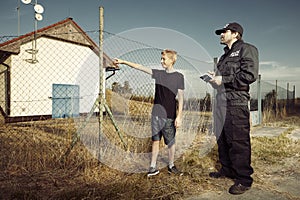 Police man questioning a teenage boy in fields