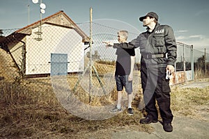 Police man questioning a teenage boy in fields