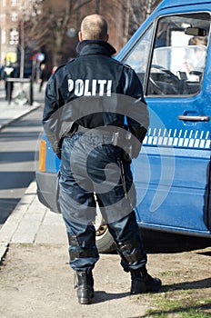 Police man, van and security in the city of Denmark for street safety, service or law enforcement patrol. Back of male