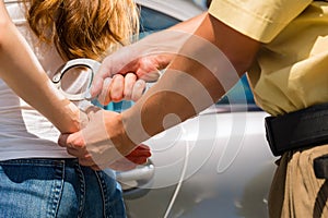 Police officer arresting a woman with handcuffs