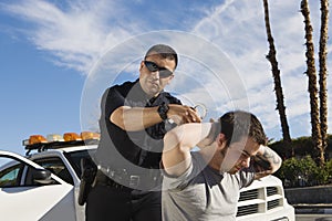 Police Officer Arresting Young Man