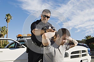 Police Officer Arresting Young Man