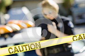 Police Officer Behind Caution Tape photo