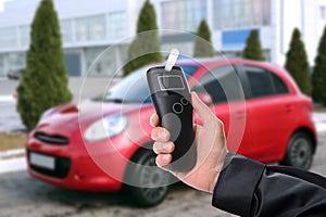 Police officer with breathalyzer near car outdoors. Alcohol consumption while driving