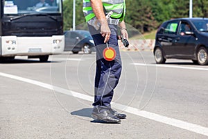 Police officer controlling traffic on the highway, bus and cars in the background