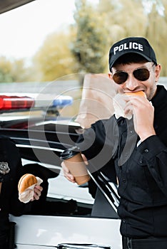 Police officer eating burger and holding