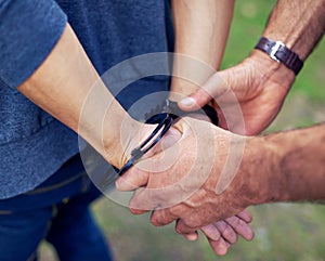 Police officer, hands and closeup to arrest person for crime with safety, legal and security service. People, law