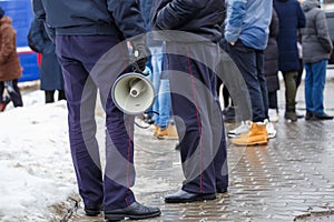 police officer holding loudspeaker megaphone outdoors, close-up