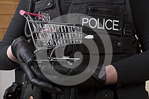 Police officer holding small shopping trolley