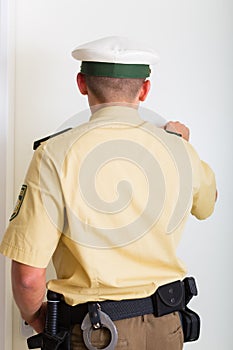 Police officer knocking on front door