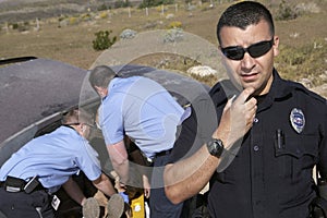 Police Officer With Paramedics Rescuing Car Accident Victim photo