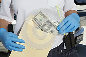 Police Officer Putting Money In Evidence Envelope