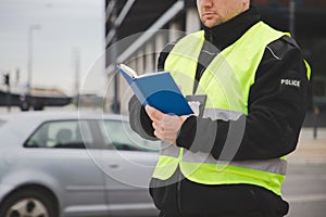 Police officer in a reflective vest writing a ticket
