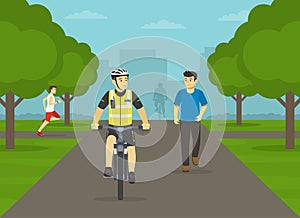 Police officer riding bike on park path. Front view of a bicycle patrol.