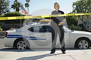 Police Officer Standing Behind Caution Tape