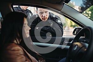 Police officers in uniform check female driver