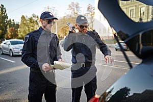 Police patrol checking the trunk of a car