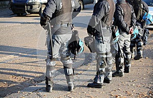 Police in riot gear with flak jackets and protective helmets and