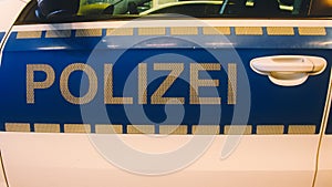 Police sign in white letters on a police car