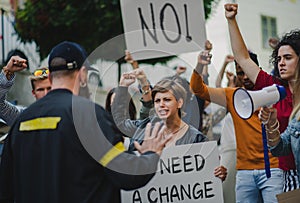 Police stopping group of people activists with raised fists protesting on streets, BLM demonstration concept.