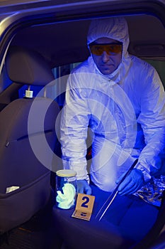 Police team working in ultraviolet light on collecting of traces and evidences