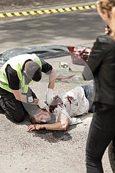 Policeman checking man's pulse