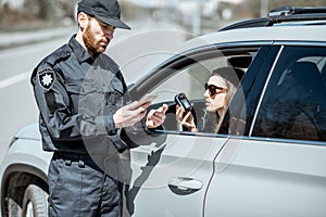 Policeman checking woman driver for alcohol intoxication