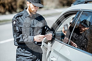 Policeman checking woman driver for alcohol intoxication