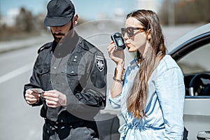 Policeman checking woman driver for alcohol intoxication