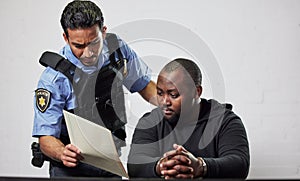 Policeman, criminal and handcuffs with documents for interrogation, question or arrest in fraud, scam or crime. Law