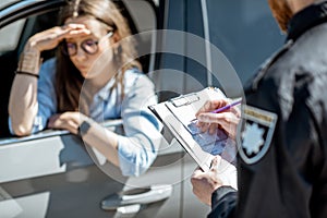 Policeman issuing a fine for a female driver