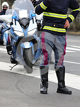policeman with leather boots and police motorcycle during roadbl