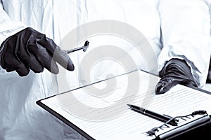 A policeman looks through a magnifying glass at the evidence at the crime scene. The crime scene of poisoning and overdosing