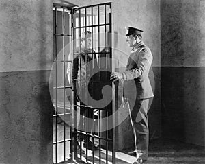 Policeman and prisoner in a jail cell