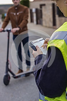 Policeman stops a boy on electric scooter