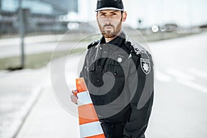 Policeman with traffic cones on the road