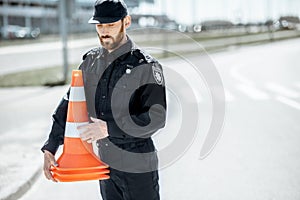 Policeman with traffic cones on the road