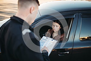 Policeman in uniform writes fine to female driver