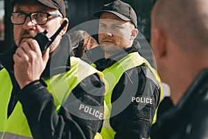 Policemen speaking on the walkie-talkie during intervention
