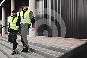 Policemen in vests looking around carefully during patrol in the city center