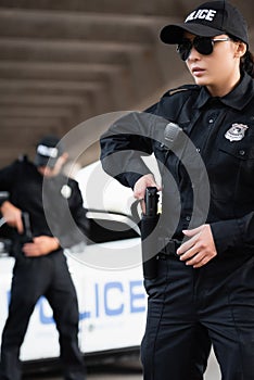 Policewoman in sunglasses taking gun from