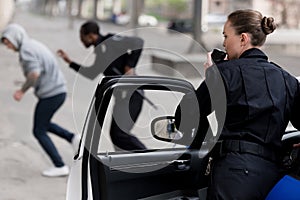 policewoman talking by radio set while her partner