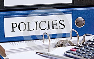 Policies - blue binder with text in the office