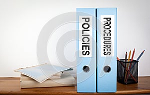 Policies and Procedures binders in the office. Stationery on a wooden shelf photo