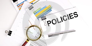 POLICIES text on white paper on light background with charts paper