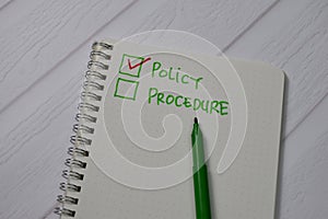 Policy and Procedure write on a book. Supported by an additional services isolated wooden table