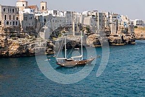 Polignano a mare breathtaking sight, Puglia, Italy. Italian panorama. Cliffs on adriatic sea and boat.