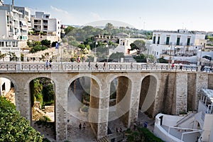 People on the Ponte Lama Monachile bridge in Polignano a Mare, Italy.