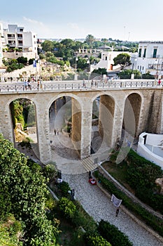 People on the Ponte Lama Monachile bridge in Polignano a Mare, Italy.